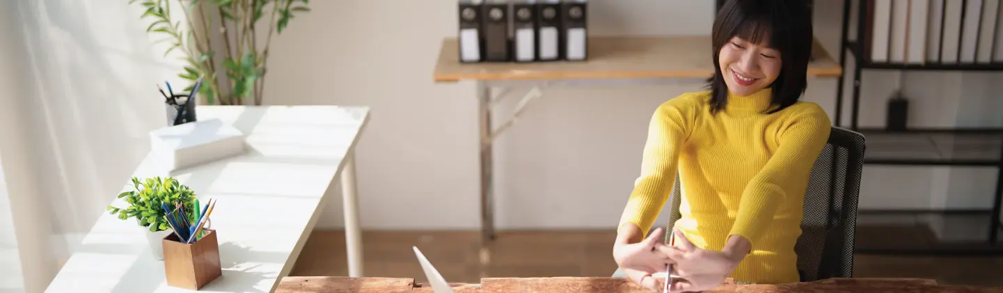 woman sitting at her desk stretching her forearms